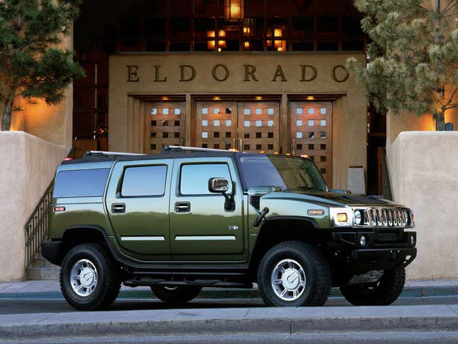 Side view of a green Hummer H2 parked outside a restaurant