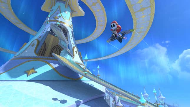 A screenshot from Mario Kart World. Shy Guy is midair on a kart while a castle is pictured in the background.