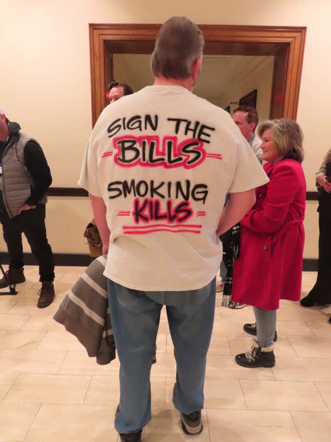 A man wears a T-shirt supporting a casino smoking ban to a hearing at which a New Jersey Senate committee advanced a bill that would ban smoking in Atlantic City&#39;s nine casinos, Monday, Jan. 29, 2024, in Trenton, N.J. The bill still needs numerous additional votes before becoming law. (AP Photo/Wayne Parry)