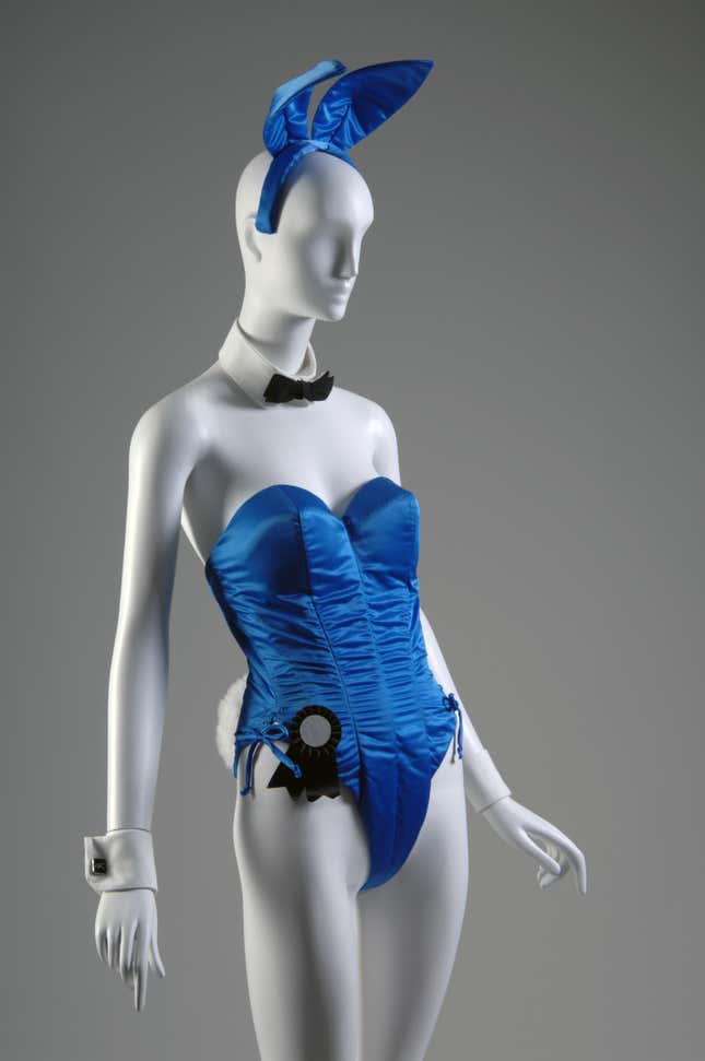 Playboy Bunny uniform: blue satin "bunny suit", coordinating tie in black cotton, coordinating collar and cuffs in white cotton, coordinating cuff links, matching rabbit ear headpiece, coordinating fake fur tail