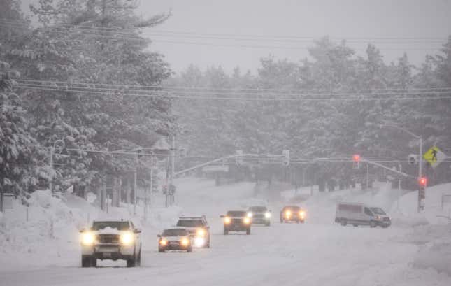 MAMMOTH LAKES, CALIFORNIA - MARCH 10: Vehicles drive as snow falls during another winter storm in the Sierra Nevada mountains on March 10, 2023 in Mammoth Lakes, California. 