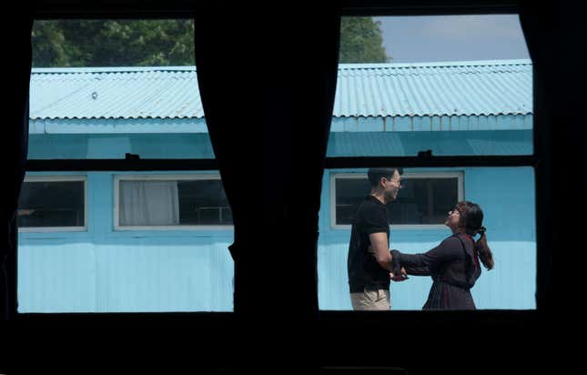 A man and woman share a light moment as they visit the replica of the truce village.