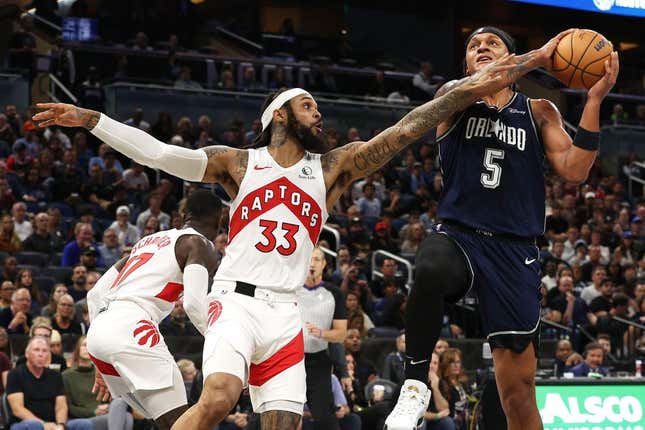 Nov 21, 2023; Orlando, Florida, USA; Orlando Magic forward Paolo Banchero (5) shoots as Toronto Raptors guard Gary Trent Jr. (33) defends during the first quarter at Amway Center.