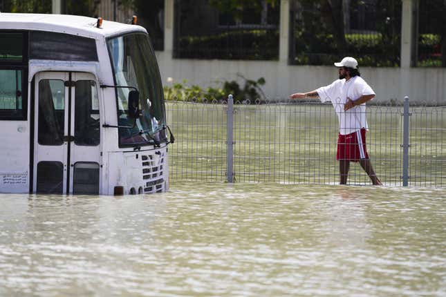 A man walks through floodwater in Dubai, United Arab Emirates, Wednesday, April 17, 2024.