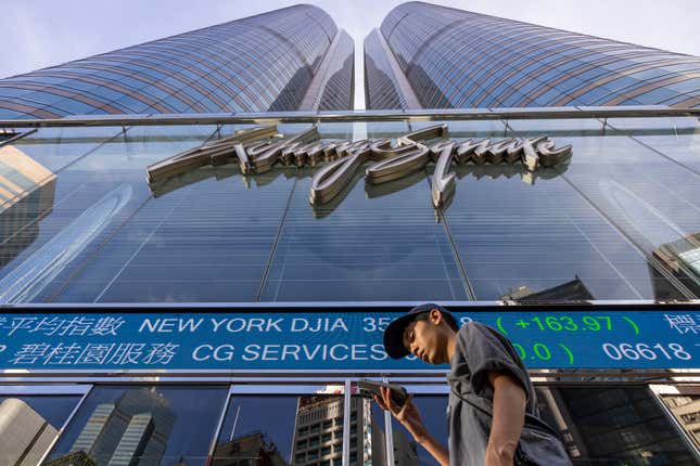 FILE - A pedestrian passes by the Hong Kong Stock Exchange electronic screen in Hong Kong on July 21, 2023. Stocks mostly slipped in mixed trading Monday, Oct. 2, as the constrictor of higher interest rates tightened its coils around Wall Street. (AP Photo/Louise Delmotte, File)