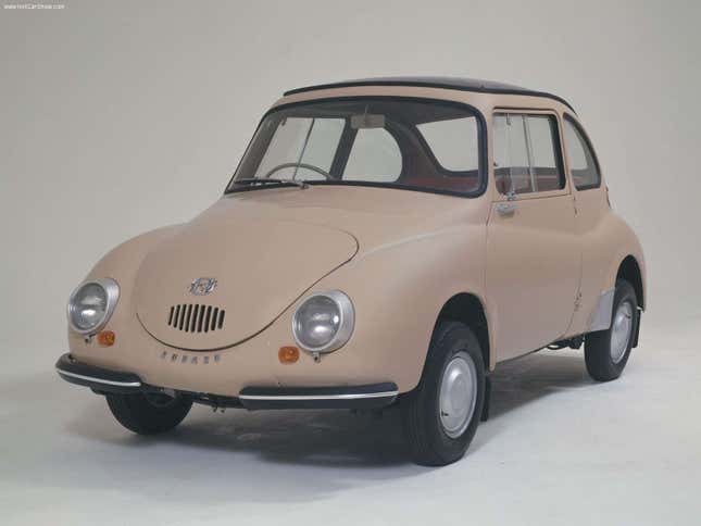 A band-aid colored Subaru 360 is parked in a white studio