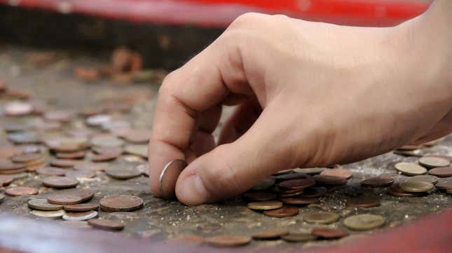 A hand holding coins