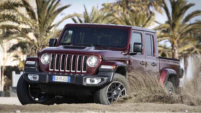 A photo of a Jeep Gladiator driving on sand. 