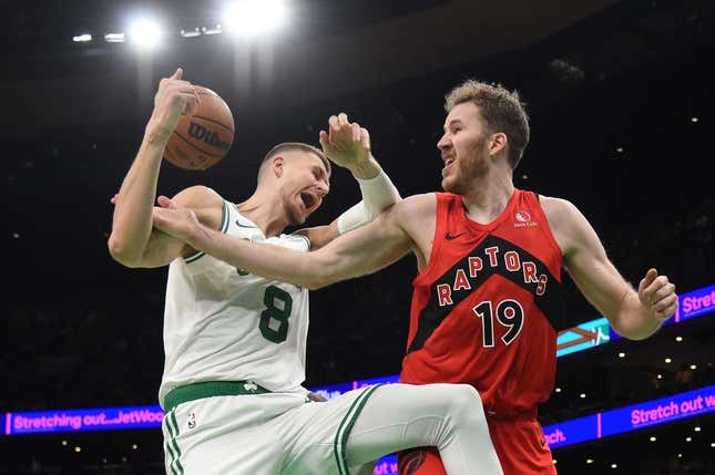 Nov 11, 2023; Boston, Massachusetts, USA;  Toronto Raptors center Jakob Poeltl (19) fouls Boston Celtics center Kristaps Porzingis (8) during the second half at TD Garden.
