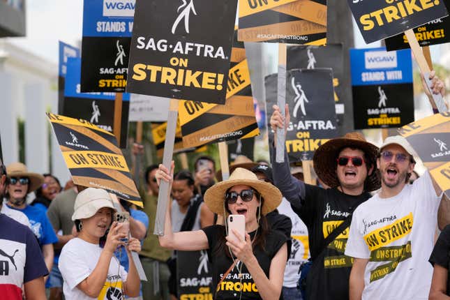 Picketers carry signs on the picket line outside Netflix on Wednesday, Sept. 27, 2023, in Los Angeles. Hollywood&#39;s writers strike was declared over Tuesday night when board members from their union approved a contract agreement with studios, bringing the industry at least partly back from a historic halt in production. The actors strike continues in their bid to get better pay and working conditions. (AP Photo/Chris Pizzello)