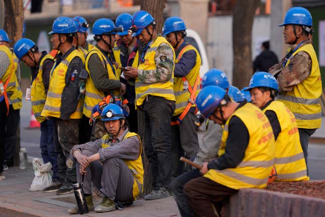 Workers wait for transport outside a construction site in Beijing, Tuesday, April 9, 2024. China&#39;s Finance Ministry has denounced a report by Fitch Ratings that kept its sovereign debt rated at A+ but downgraded its outlook to negative, saying in a statement that China&#39;s deficit is at a moderate and reasonable level and risks are under control. (AP Photo/Ng Han Guan)