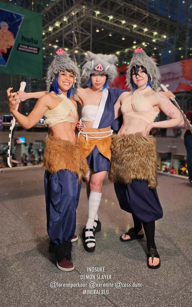 Three buff, femme Inosuke cosplayers flex at Anime NYC 2023.