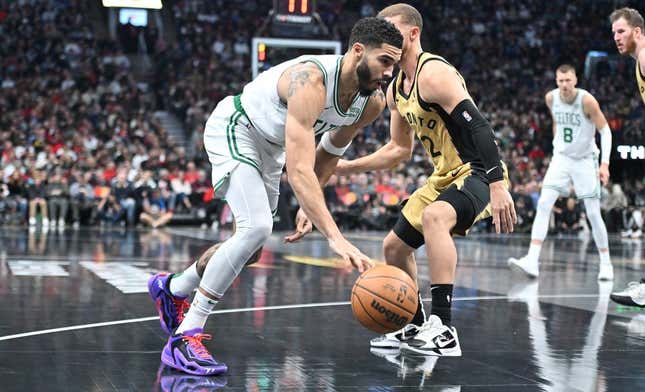 Nov 17, 2023; Toronto, Ontario, CAN;   Boston Celtics forward Jayson Tatum (0) dribbles the ball past Toronto Raptors guard Malachi Flynn (22) in the first half at Scotiabank Arena.