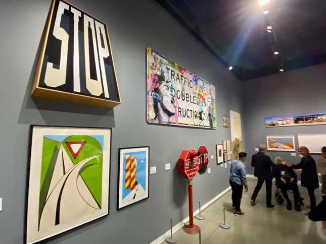 A photo of the sign section of the exhibit, showing some historical road signs and some artistic interpretations of street signs.
