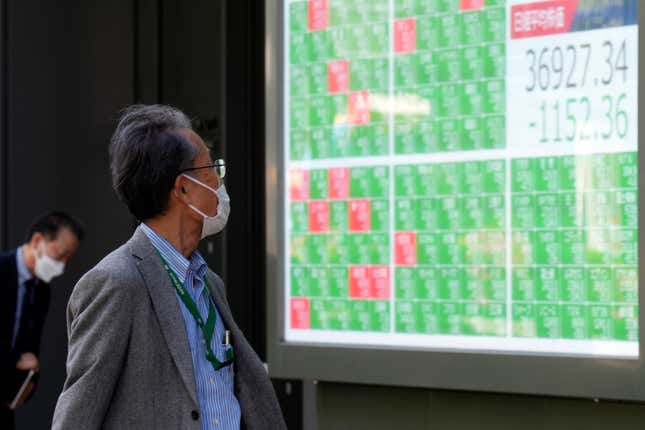 FILE - A person looks at an electronic stock board showing Japan&#39;s Nikkei 225 index at a securities firm in Tokyo, on April 19, 2024. Asian benchmarks extended gains Tuesday, April 23, after U.S. stocks clawed back a chunk of their losses from the previous week.(AP Photo/Eugene Hoshiko, File)