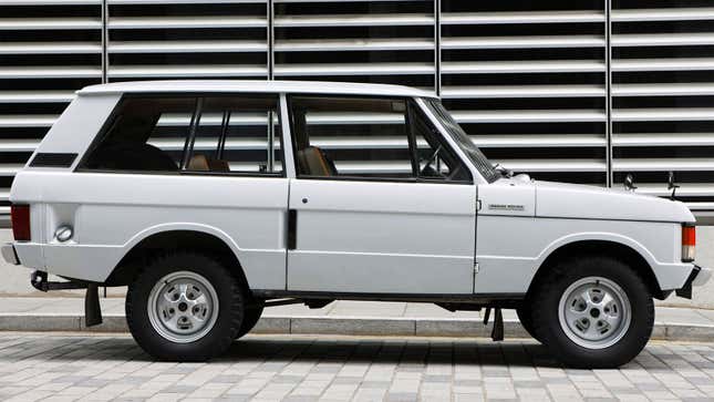 A photo of a white Range Rover three-door marked on a street. 