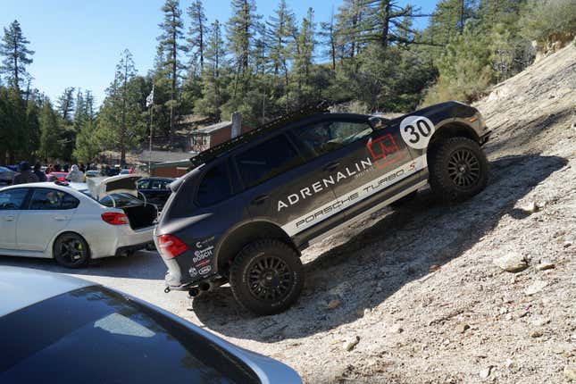 A off-road modified Porsche Cayenne Turbo S is parked on a steep dirt hill.