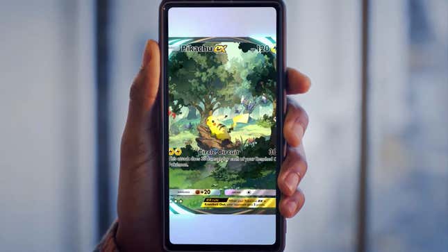 A player holds up a phone showing a Pikachu card.