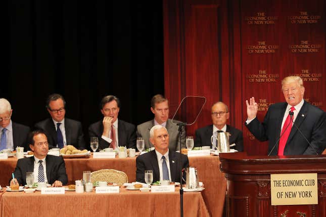 NEW YORK, NY – 15. SEPTEMBER: Der republikanische Präsidentschaftskandidat Donald Trump spricht bei einem vom Economic Club of New York veranstalteten Mittagessen am 15. September 2016 in New York City. Hinter Trump sitzen John Paulson (links), ein amerikanischer Hedgefonds-Manager, und Mike Pence, Trumps Vizepräsidentschaftskandidat. Laut einem Bericht von Oxford Economics wäre das Wachstum in den USA bis 2021 um etwa 5 Prozent niedriger als sonst erwartet. 