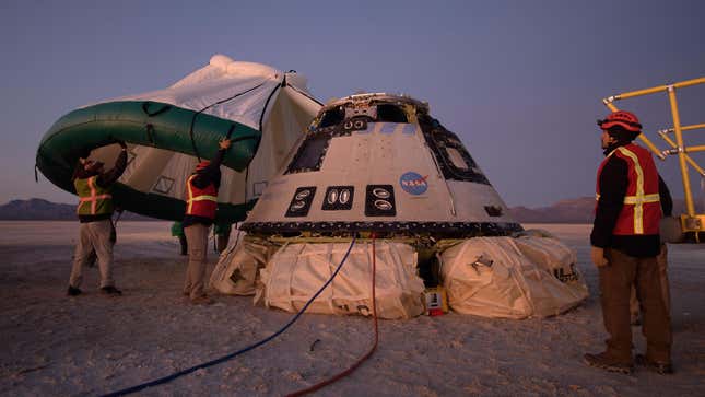 Boeing, NASA, and U.S. Army personnel work around the Boeing CST-100 Starliner spacecraft shortly after it landed in White Sands, New Mexico, Sunday, Dec. 22, 2019.