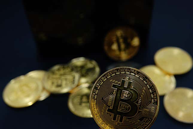 gold coins with the bitcoin symbol against a black backdrop