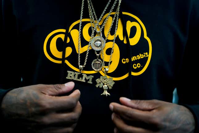 Cloud 9 Cannabis CEO and co-owner Sam Ward Jr. wears chains among over a custom hoodie, Saturday, April 13, 2024, in Arlington, Wash. The shop is one of the first dispensaries to open under the Washington Liquor and Cannabis Board&#39;s social equity program, established in efforts to remedy some of the disproportionate effects marijuana prohibition had on communities of color. (AP Photo/Lindsey Wasson)