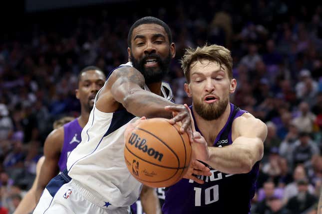 SACRAMENTO, CALIFORNIA - MARCH 26: Domantas Sabonis #10 of the Sacramento Kings and Kyrie Irving #11 of the Dallas Mavericks go for a loose ball in the first half at Golden 1 Center on March 26, 2024 in Sacramento, California. NOTE TO USER: User expressly acknowledges and agrees that, by downloading and or using this photograph, User is consenting to the terms and conditions of the Getty Images License Agreement. (Photo by Ezra Shaw/Getty Images)