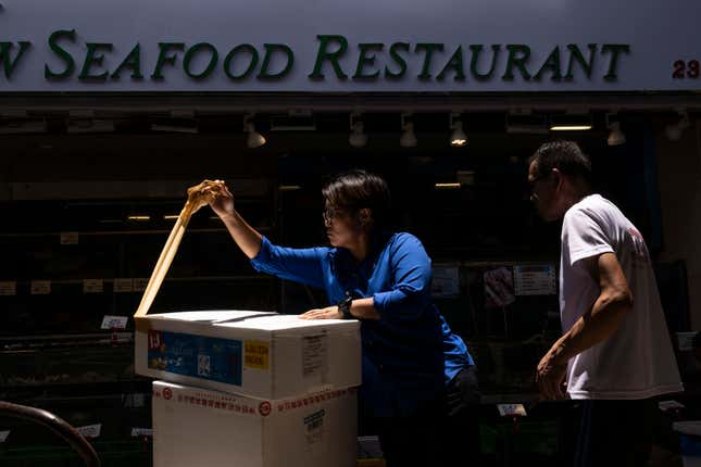 Restaurant workers open up a parcel of abalone from South Africa bought at the Aberdeen Wholesale Fish Market in Hong Kong, Thursday, June 29, 2023. (AP Photo/Louise Delmotte)