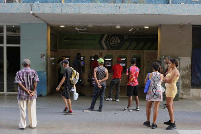 People stand in line outside a bank hoping to withdraw Cuban pesos from an ATM, in Havana, Cuba, Monday, April 22, 2024. An increasing number of Cubans are having to grapple with the country&#39;s shortage of cash. (AP Photo/Ariel Ley)