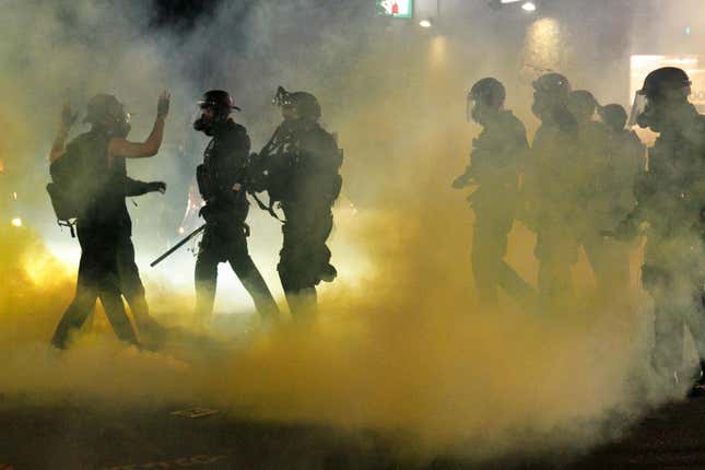 Police confront demonstrators as Black Lives Matter supporters demonstrate in Portland, Oregon on July 4, 2020 for the thirty-eighth day in a row at Portland’s Justice Center and throughout Portland, with a riot declared about 12.20 am on July 5. CS tear gas and less-lethal weapons were used, and multiple arrests were made. 