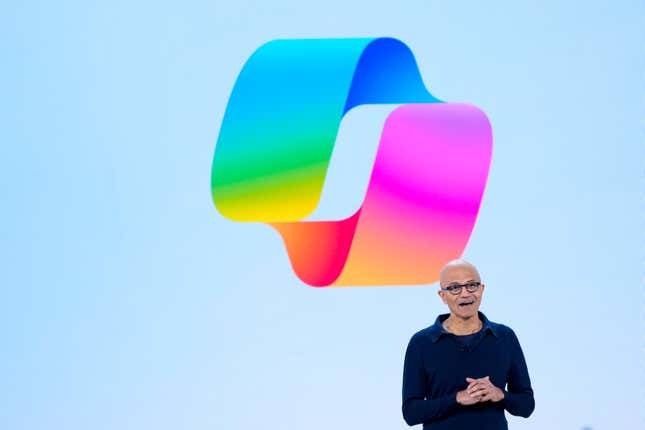 Satya Nadella standing in front of a Copilot logo