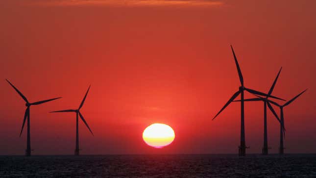 The sun starts to rise behind an offshore wind farm off the Great Yarmouth coastline.