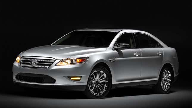 A studio photo of a silver Ford Taurus. 