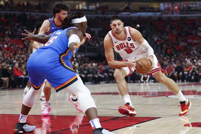 Oct 25, 2023; Chicago, Illinois, USA; Chicago Bulls center Nikola Vucevic (9) looks to pass the ball against Oklahoma City Thunder guard Luguentz Dort (5) during the first half of a basketball game at United Center.