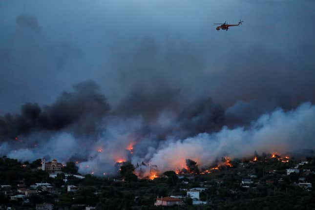 A firefighting helicopter flies over Rafina.