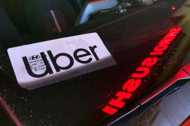 FILE - An Uber sign is displayed inside a car in Glenview, Ill., Saturday, Dec. 17, 2022. Consumers will pay more for that airline flight or willing to fork out more for a ride on Uber during rush hour. But a big shopper backlash to media reports this past week that fast-food chain Wendy’s had plans to increase prices during the busiest time at its restaurants clearly showed that consumers don’t want basic food items like hamburgers and shakes going up and down(AP Photo/Nam Y. Huh, File)