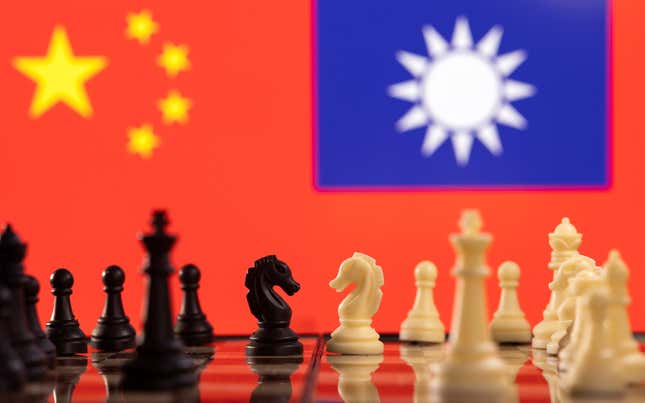 Chess pieces are seen in front of displayed China and Taiwan's flags