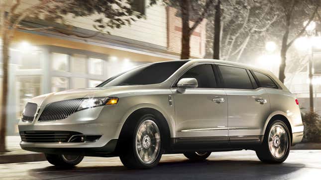 A beige Lincoln MKT drives on a road. 