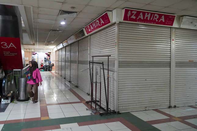 A person walks by closed and deserted shops in the Tanah Abang textile market in Jakarta, Indonesia, Thursday, Sept. 28, 2023. Chinese-owned app TikTok on Thursday said it regretted the Indonesian government&#39;s decision to ban e-commerce transactions on social media platforms, particularly the impact it would have on the millions of sellers who use TikTok Shop. (AP Photo/Tatan Syuflana)