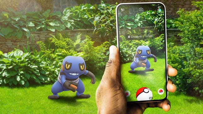 Un Croagunk est vu dans une zone herbeuse avec une personne qui tient son téléphone et le regarde à travers la caméra.