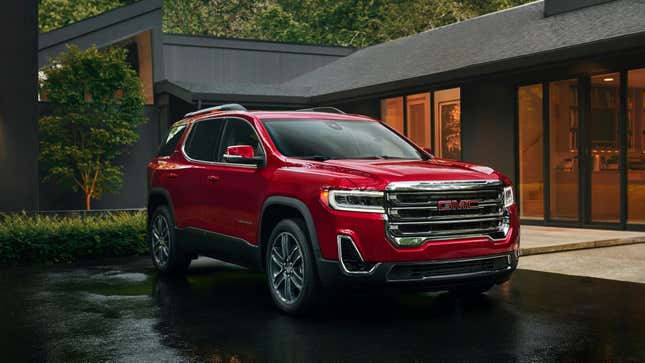 a red GMC Acadia parked in front of a building