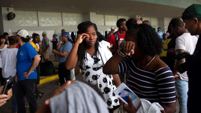 Two women cry after arriving at the Port of Palm Beach on the cruise ship Grand Celebration Sept. 7, 2019, in West Palm Beach, Fla. The ship arrived with hundreds of evacuees impacted by Hurricane Dorian in the Bahamas.