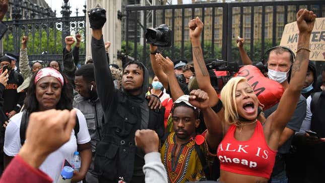 John Boyega raises a fist of solidarity alongside protesters outside Parliament Square in London, England.