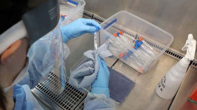 A lab technician handles a test tube with a live sample from a person tested for the novel coronavirus.