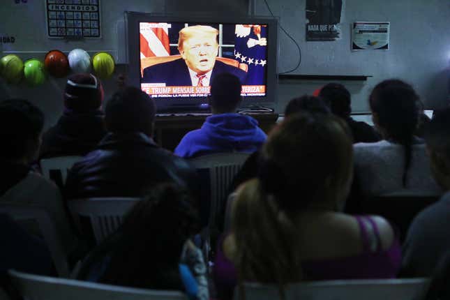 Migrants view a live televised speech by President Donald Trump on border security at a shelter for migrants on January 8, 2019 in Tijuana, Mexico. Tijuana continues to house migrants, many of whom are hoping to cross the border into the U.S.