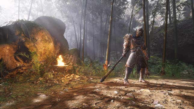  Wukong shows an armored figure standing in a forest near a large boulder and a fire.