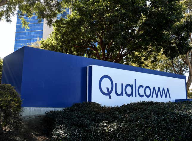 a Qualcomm surrounded by bushes and trees with a building in the background