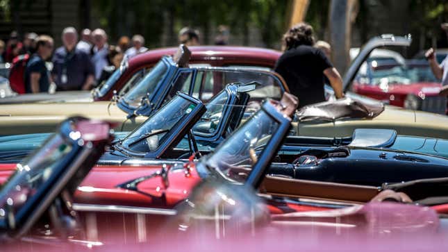 A photo of a lineup of classic cars on show. 