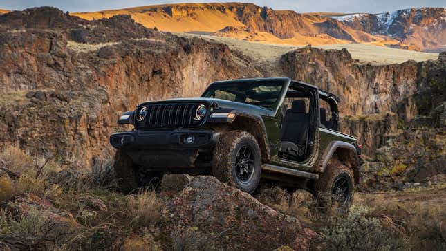 Une photo d’une Jeep Wrangler vert foncé conduisant hors route. 