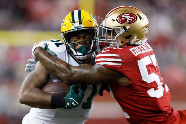 SANTA CLARA, CALIFORNIA - JANUARY 20: Dre Greenlaw #57 of the San Francisco 49ers tackles Emanuel Wilson #31 of the Green Bay Packers during the first half in the NFC Divisional Playoffs at Levi&#39;s Stadium on January 20, 2024 in Santa Clara, California. (Photo by Lachlan Cunningham/Getty Images)